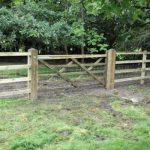 Horse gate with post and rail fencing and netting